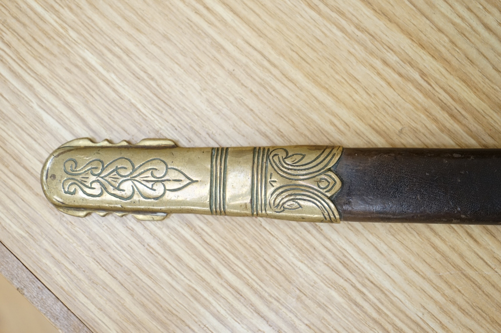 A post 1902 Naval Officer’s Dirk, the regulation blade with crowned fouled anchor, regulation hilt with remains of bullion dress knot in its leather scabbard with brass mounts, locket engraved with owners initials; RSA